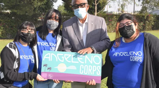 Group holding sign 'Angelo Corps'